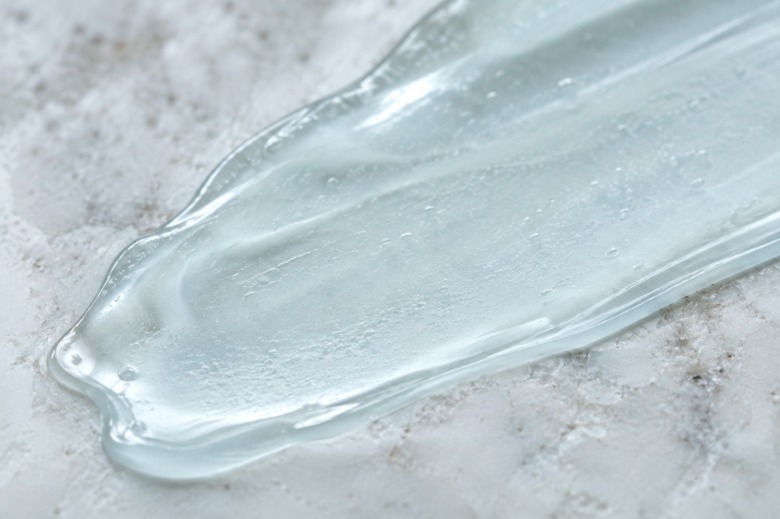 Một vệt gel trong suốt trải dài trên mặt đá cẩm thạch trắng, lấm tấm những bọt khí nhỏ bên trong